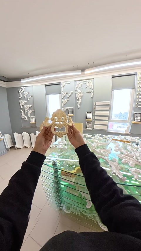 Mano che tiene un ornamento applique dorato vicino alle colonne