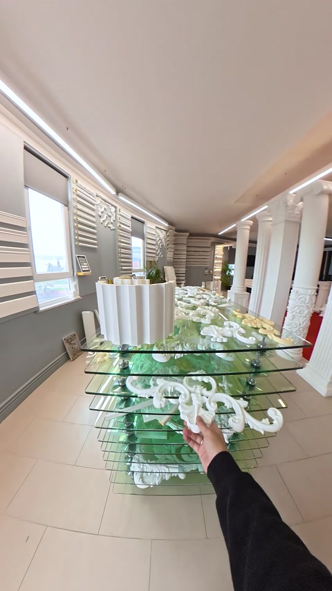Tavolo in vetro pieno di pezzi di cornici decorative sovrapposti