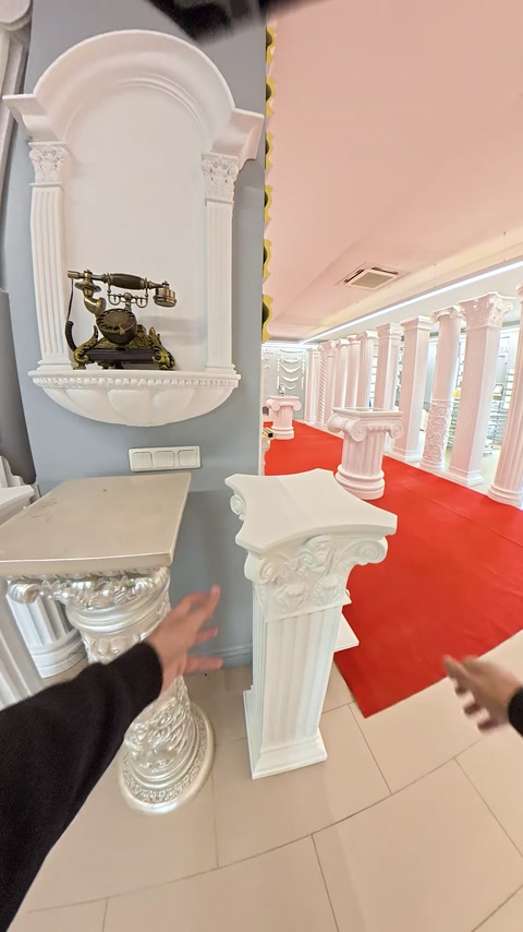 Telefono vintage esposto accanto a un capitello di colonna ornamentale