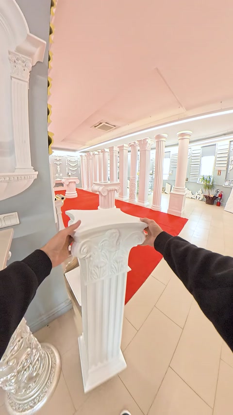 Mano che tiene un pezzo di capitello ornamentale vicino alla sommità di una colonna