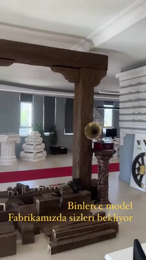 Una trave decorativa effetto legno e mensole incorniciano il passaggio dello showroom