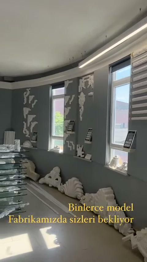 Duvar sergisinin önünde paketlenmiş uzun dekorasyon parçaları görülüyor