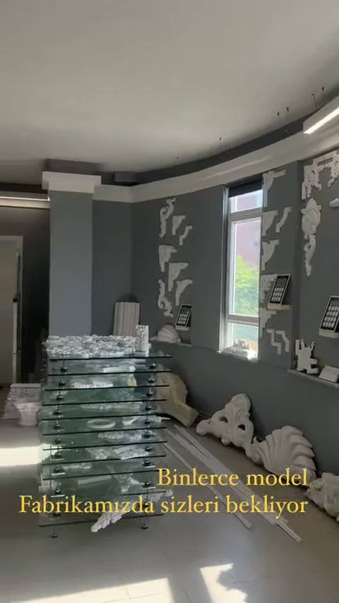 Showroom alanında istiflenmiş paketler ve duvar süsleri sergileniyor