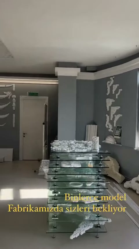Gri duvarda ince süslemeler, köşe parçaları ve bordürler bulunuyor