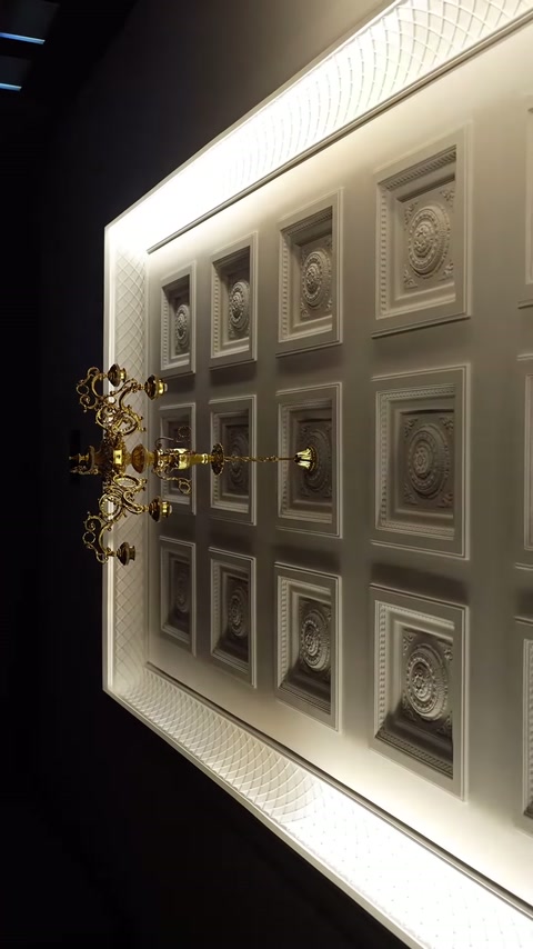 Una banda di luce perimetrale mette in evidenza la sezione del soffitto rivestita con cupole quadrate.