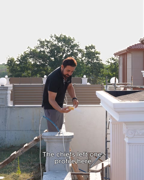 A craftsman applies a stringcourse moulding to the roof balustrade