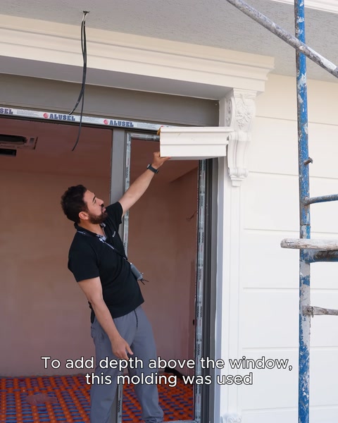 A surround is installed above a window to create depth