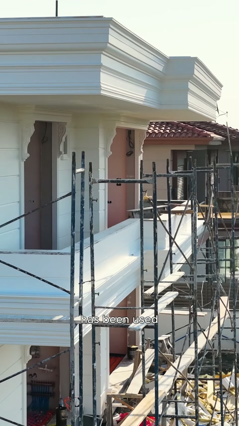 The entrance facade behind the scaffold features thick soffits and columns.