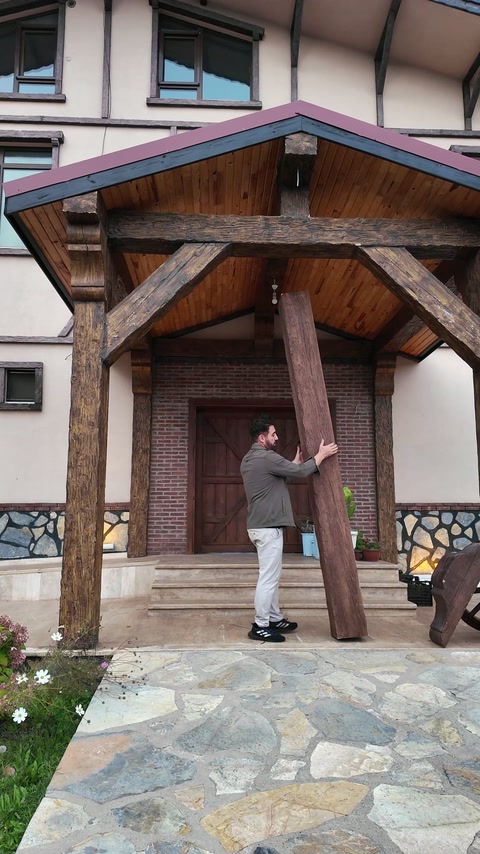 Presenter demonstrates a long wood-look beam beneath the entrance canopy.