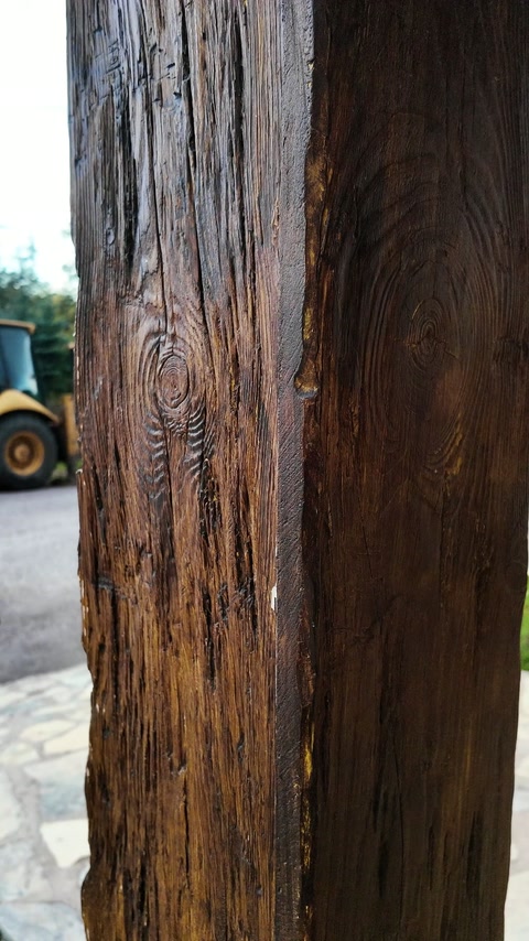 Close-up reveals pronounced grain across the dark brown decorative post.