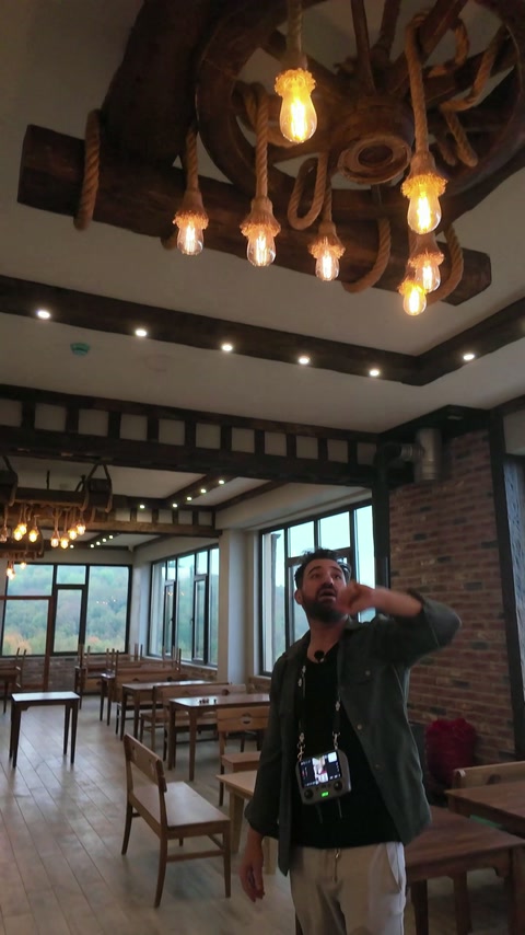 Wide interior view shows repeated beam bands and suspended lighting.