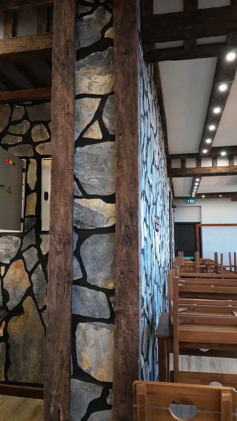 Vertical beam trim defines the corner of the stone-patterned wall.