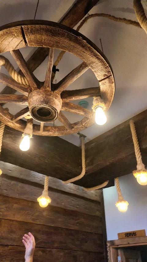 Close view shows wagon-wheel lighting suspended from a decorative beam.