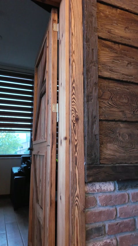 Wood-look cladding and trim meet beside the brick wall.