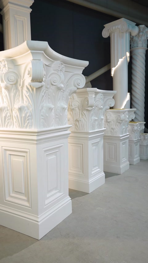 Capitelli per colonne decorati su basi alte sono mostrati da un'angolazione obliqua.