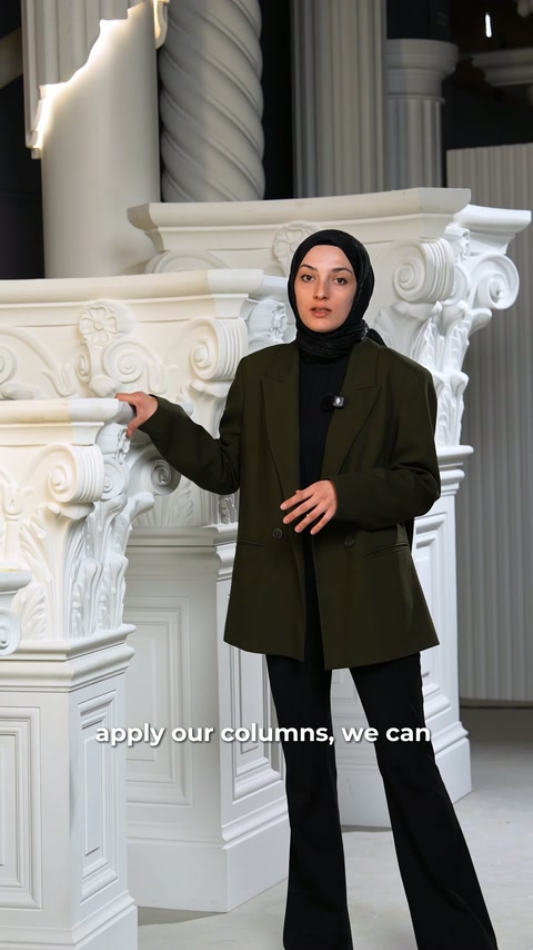 Sunucu, kabartmalı sütun başlıklarının önünde model seçeneklerini eliyle anlatıyor.