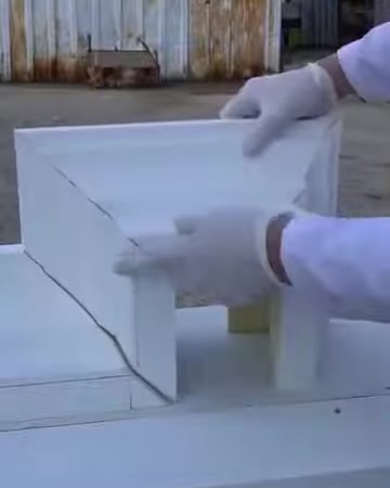 L'installatore controlla con un guanto la linea di taglio diagonale su un elemento della cornice