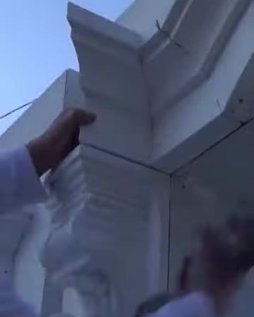 L'installatore posiziona con attenzione un elemento della cornice in poliuretano sull'angolo della facciata