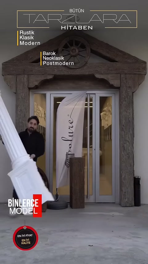Un artigiano porta una colonna decorativa bianca verso l'area rustica dell'ingresso
