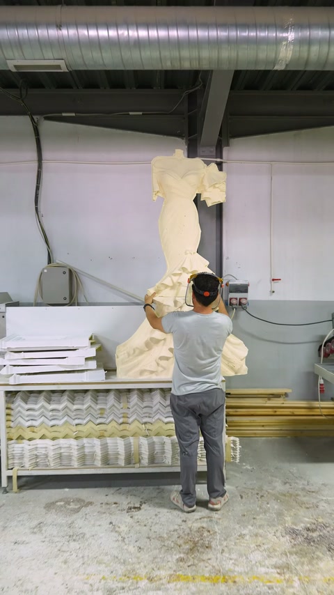 Technician positions the full-length bridal sculpture upright inside the production workshop.
