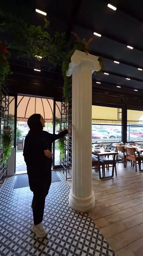 Sunucu, tamamlanmış İyon sütunun başlık bölümünü restoran içinde işaret ediyor.