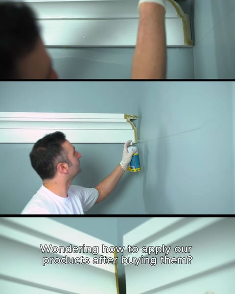 Installing a cornice on a wall by pressing it into place with a gloved hand