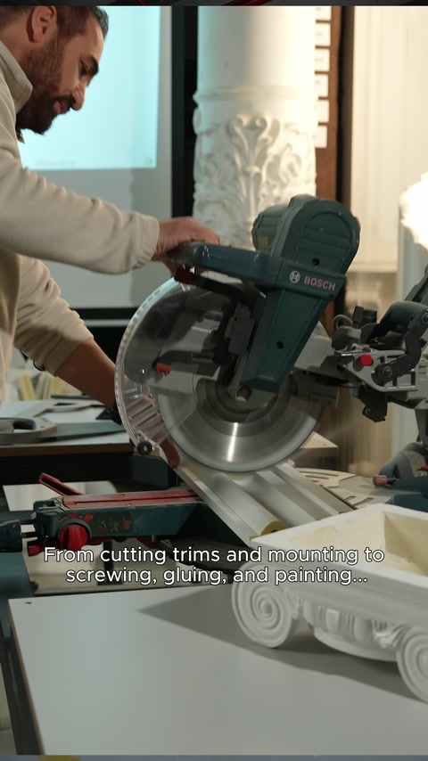 Un profilo decorativo elaborato viene tagliato in laboratorio con una sega a goniometro.