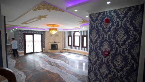 A patterned wall covering and illuminated ceiling decoration in the living room