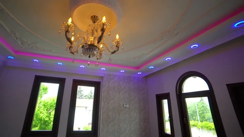 Cornice frames and colored concealed lighting on a chandelier ceiling