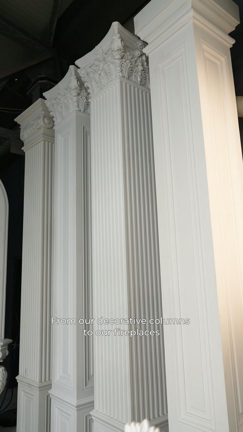 Long fluted columns with various capital designs are arranged in the showroom.