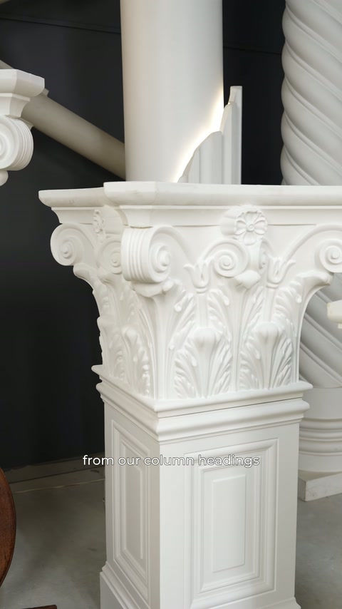 A Corinthian capital with leaf decoration is displayed on a plain column shaft.
