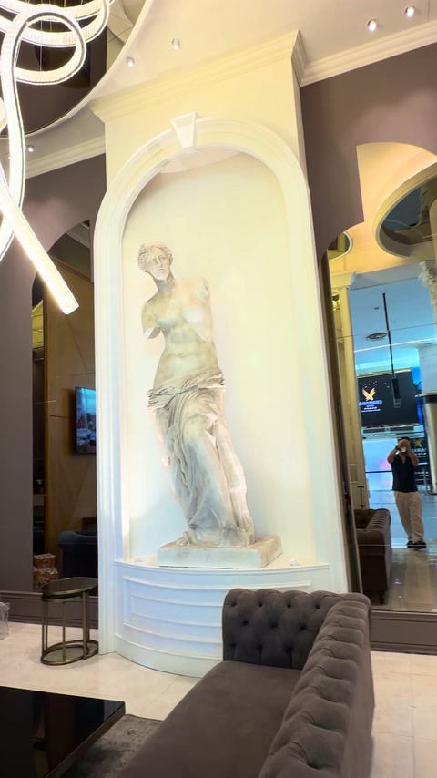 Nicchia scultorea ad arco bordata da modanature decorative bianche sovrapposte