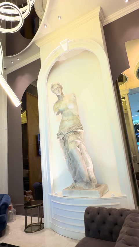 Statua classica esposta in una nicchia murale decorata e delicatamente illuminata