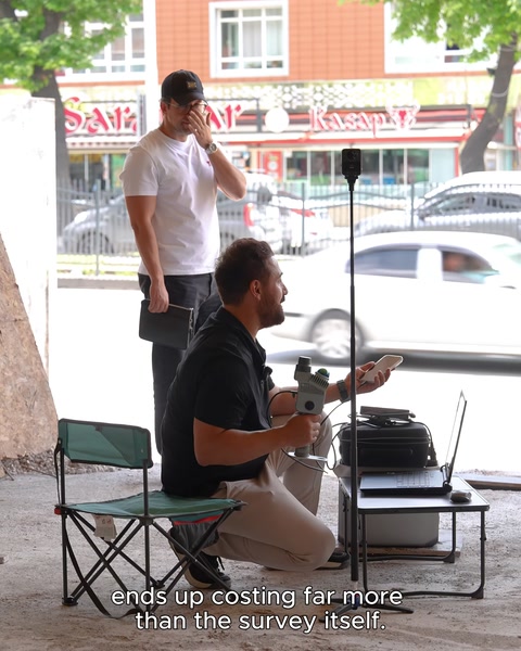 Due persone che conducono intervista con attrezzature di misurazione portatili in strada
