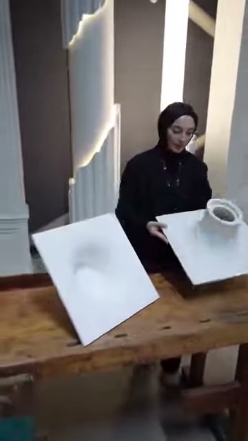 Il pannello in rilievo con aperture circolari viene abbassato verso il tavolo