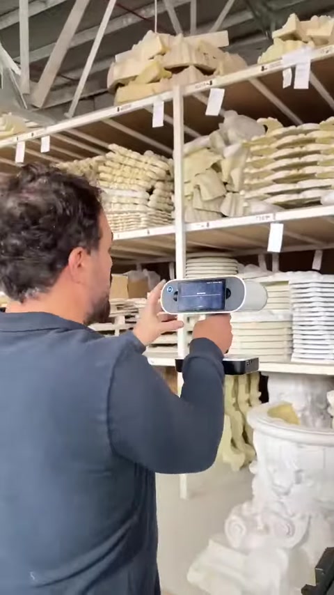 Uno scanner 3D portatile viene diretto verso un capitello su uno scaffale