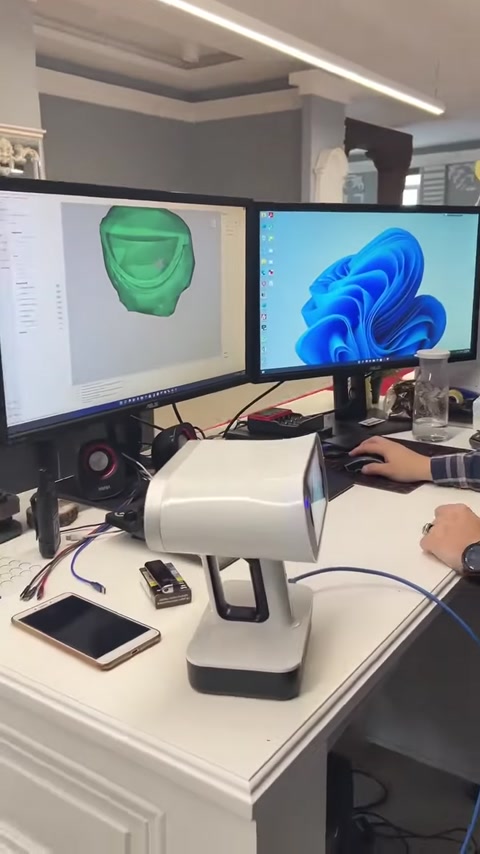 Uno scanner 3D da tavolo opera insieme a un modello digitale di capitello