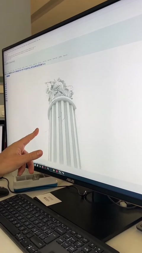 Il progetto tridimensionale completato di una colonna con motivi classici viene esaminato sullo schermo