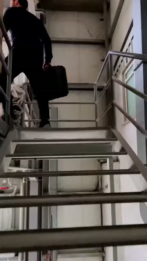 L'addetto raggiunge la sezione superiore del magazzino salendo i gradini metallici.