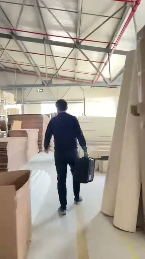 L'addetto con la borsa attraversa elementi decorativi allineati.