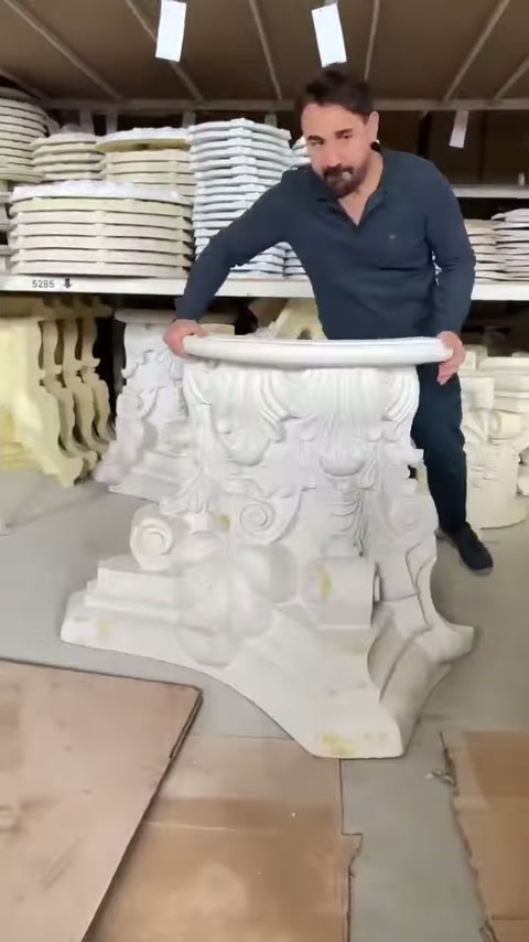 L'addetto estrae il capitello di colonna in rilievo dallo scaffale.