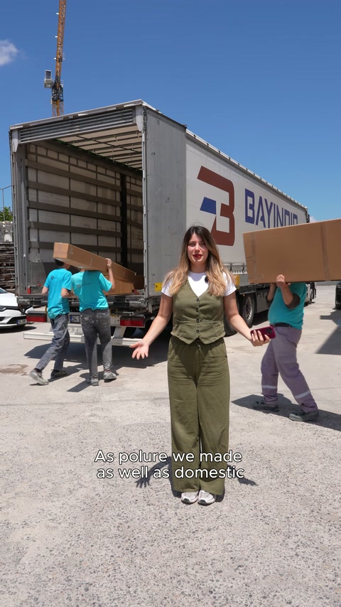 Workers carry boxed polyurethane decorative products into the truck bed.