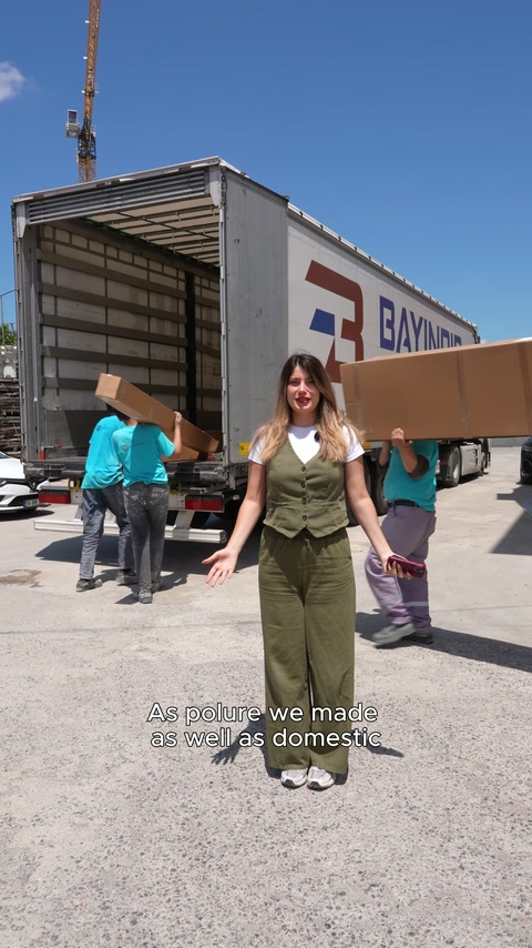As the presenter speaks, the team loads large packages into the delivery vehicle.