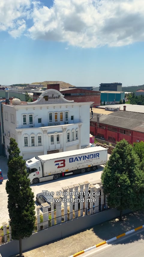 The delivery vehicle waits in front of the factory building for loading.