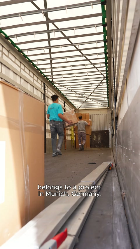 Boxed products are lined up along the side wall of the truck bed.
