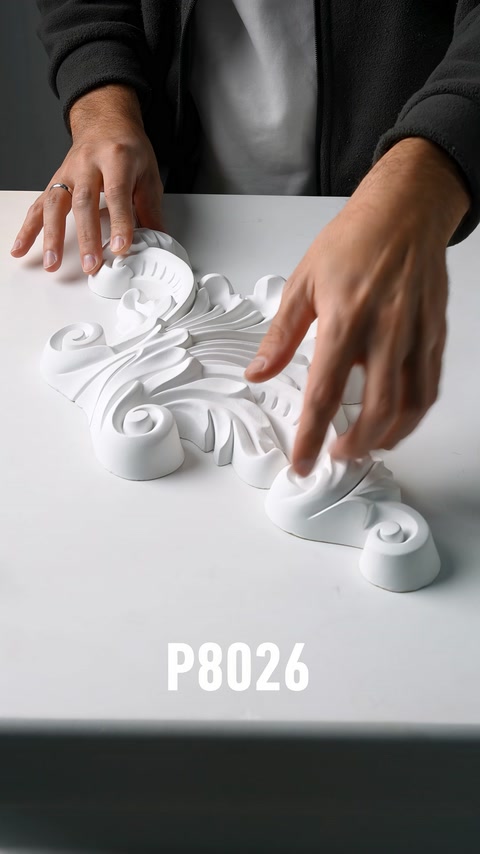 Viene controllata la texture di un'applique in poliuretano con motivi vegetali