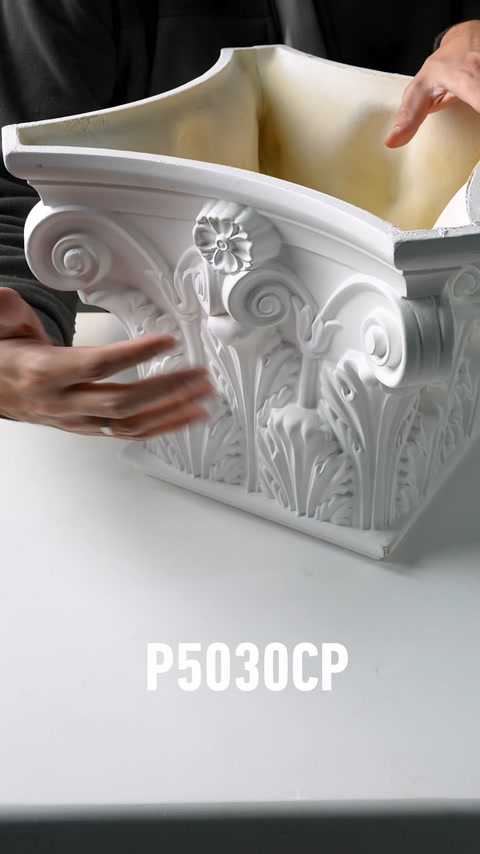 The raised details of an ornate polyurethane column capital are displayed up close
