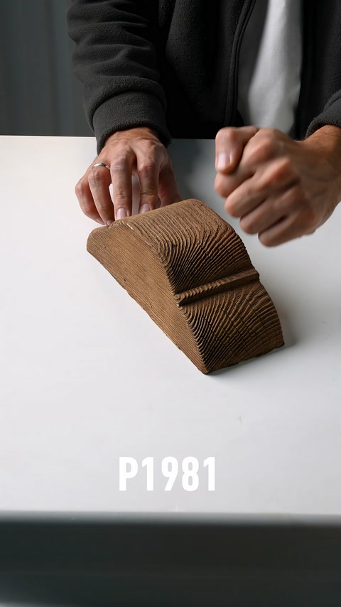 A wood-look decorative beam piece is tapped to demonstrate its texture