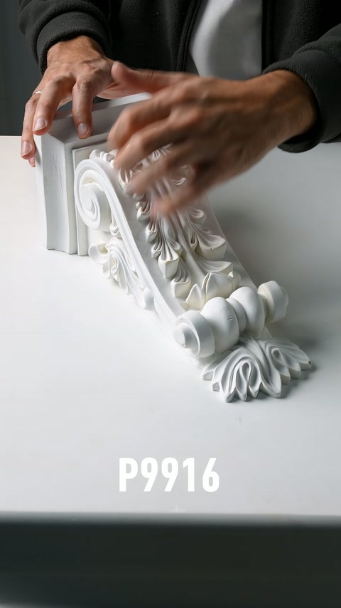 I motivi a foglia di una parte di console decorativa vengono palpati manualmente su un tavolo