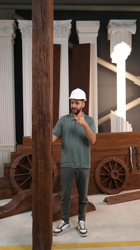 Il presentatore illustra un elemento verticale effetto legno tra gli allestimenti architettonici dello showroom
